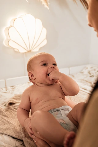Ein aufmerksames Baby auf dem Wickelplatz mit seiner Bezugsperson