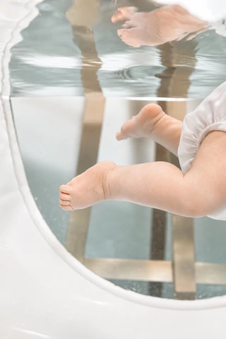 Babyfüße bewegen sich unter der Wasseroberfläche