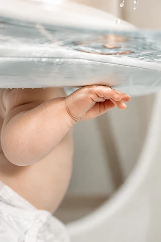 Detail einer Babyhand unter der Wasseroberfläche