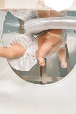 Ein Baby bewegt sich beim Floating im Wasser