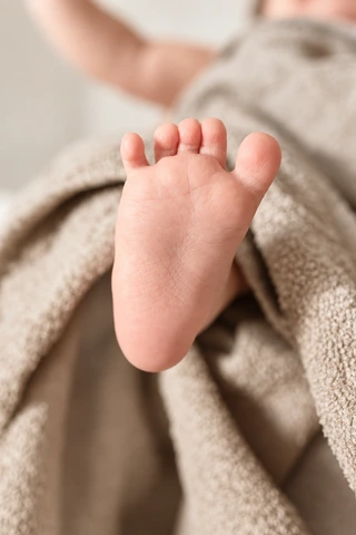 Nahaufnahme eines Babyfußes auf einem weichen Handtuch