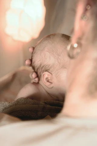 Ein Baby kuschelt an der Schulter seiner Mutter
