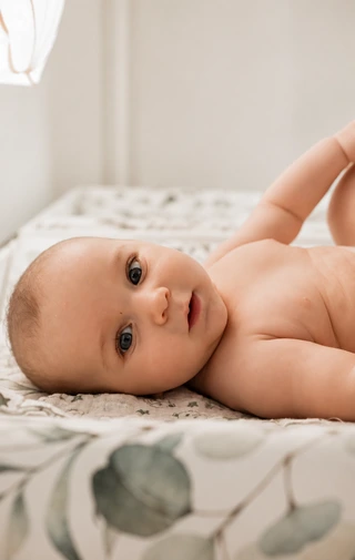Ein Baby liegt auf einer weichen Unterlage