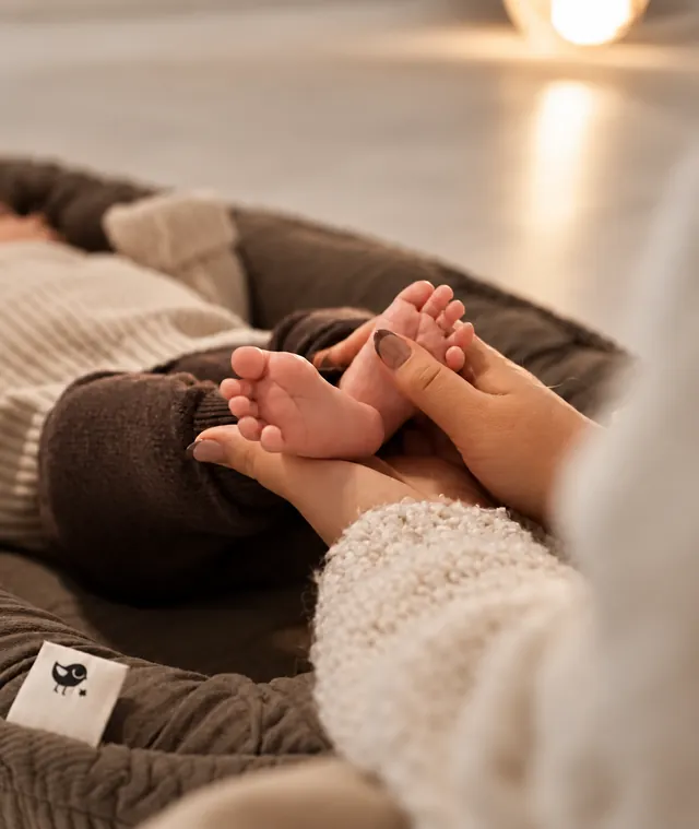 Liebevolle Massage der Babyfüße im warmen Babyboom-Studio